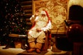 Santa Claus is sitting in his office by the fireplace